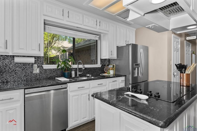 kitchen with island range hood, dark stone countertops, white cabinetry, and stainless steel appliances