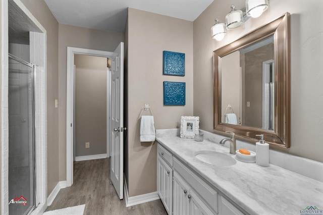 bathroom with hardwood / wood-style floors, vanity, and an enclosed shower