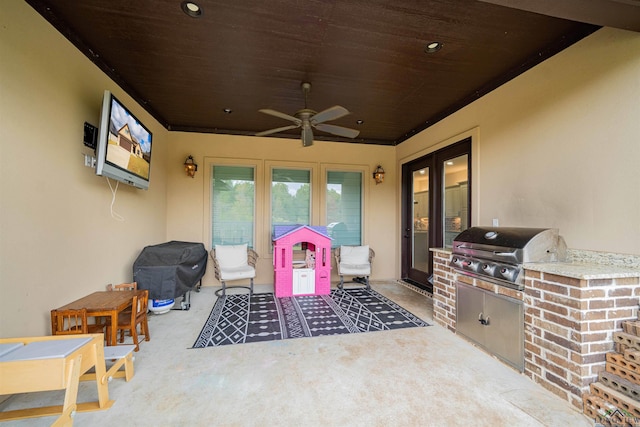 view of patio featuring grilling area, ceiling fan, and exterior kitchen