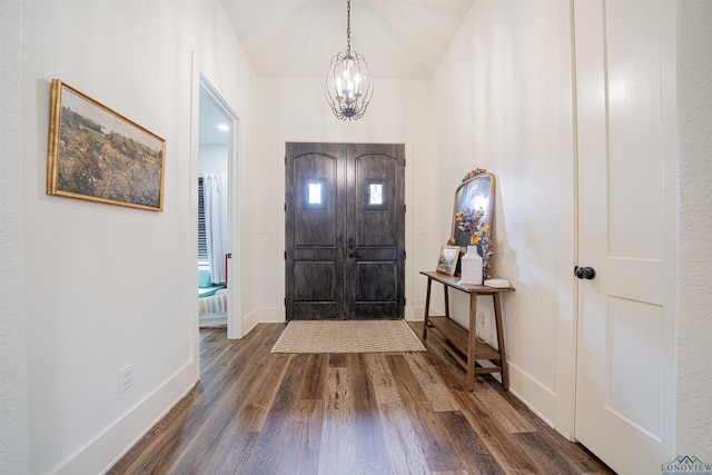 entrance foyer featuring dark hardwood / wood-style flooring and a chandelier