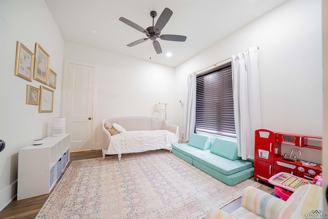 living area with hardwood / wood-style floors and ceiling fan