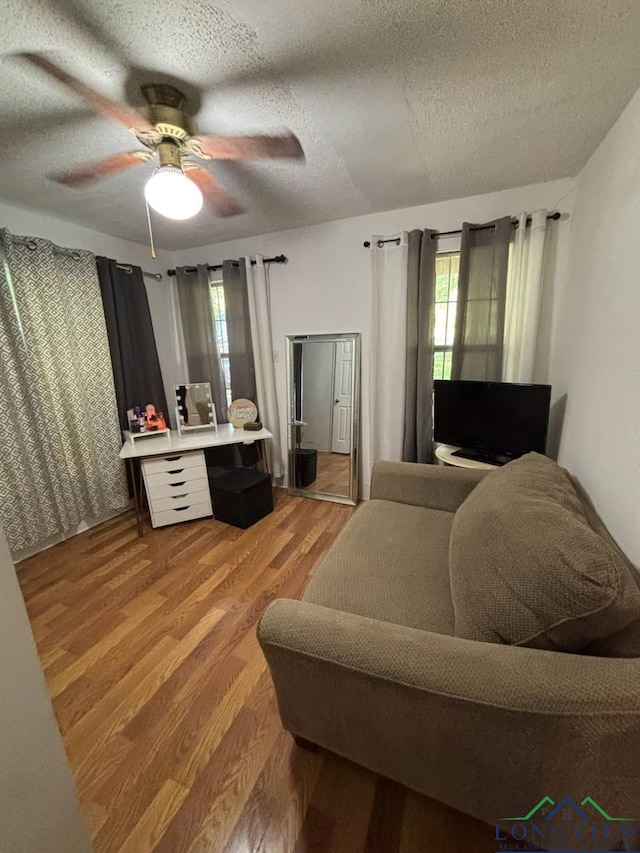 323 Gates St, Longview, TX 75601 - bedroom featuring wood finished floors, a textured ceiling, and a ceiling fan