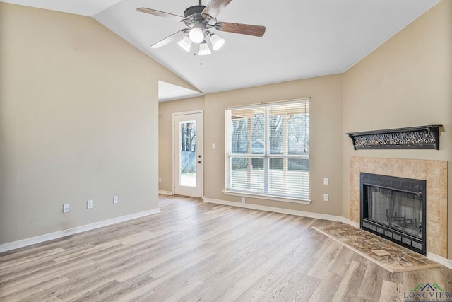 unfurnished living room featuring a ceiling fan, baseboards, light wood finished floors, lofted ceiling, and a fireplace