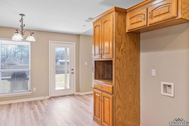 kitchen with baseboards, a chandelier, pendant lighting, light wood-type flooring, and brown cabinetry