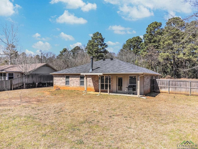 back of property featuring a patio area, a lawn, brick siding, and a fenced backyard