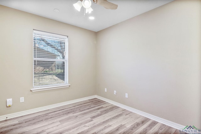 spare room with light wood-type flooring, baseboards, and ceiling fan