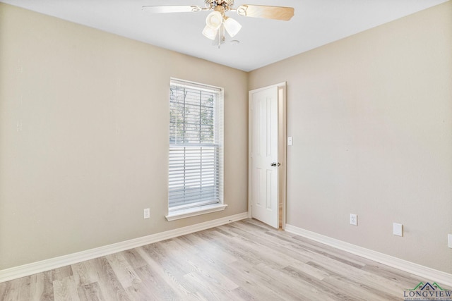 spare room featuring baseboards, ceiling fan, and light wood finished floors