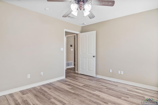 unfurnished room with baseboards, light wood-style floors, visible vents, and ceiling fan