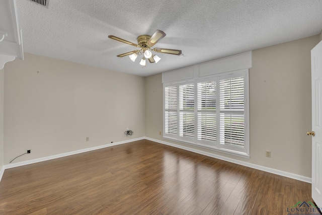 spare room featuring baseboards, a ceiling fan, wood finished floors, and a textured ceiling