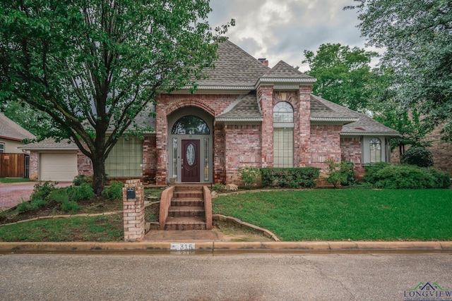 315 Tealwood Dr, Longview, TX 75605 - view of front of property with a shingled roof, brick siding, driveway, and a front lawn
