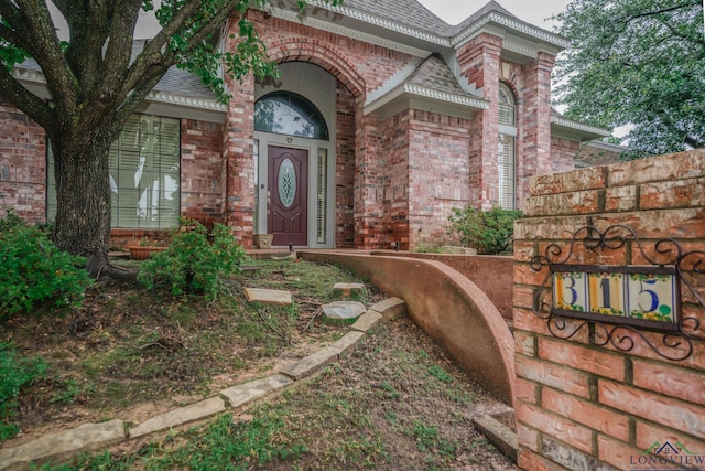 315 Tealwood Dr, Longview, TX 75605 - view of exterior entry featuring brick siding and a shingled roof