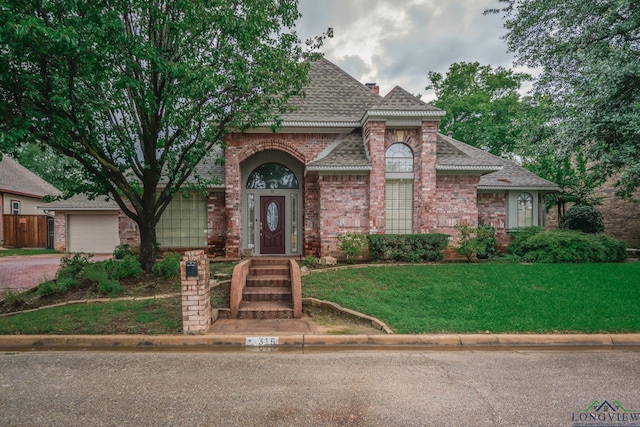 315 Tealwood Dr, Longview, TX 75605 - view of front facade featuring roof with shingles, a front lawn, brick siding, and driveway