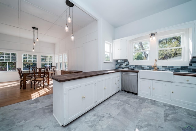 kitchen with white cabinets, dishwasher, decorative light fixtures, backsplash, and kitchen peninsula