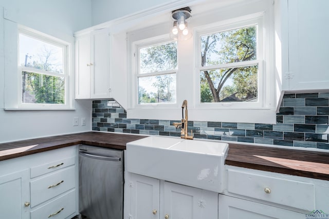 kitchen with sink, backsplash, wood counters, and white cabinetry