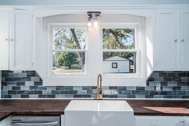 kitchen with white cabinets, sink, and a healthy amount of sunlight