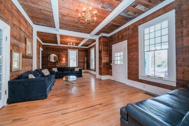 living room with wood walls, wooden ceiling, beam ceiling, and an inviting chandelier