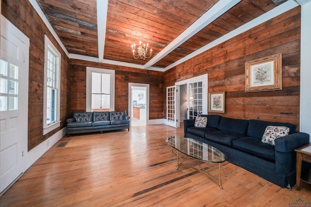 living room featuring beam ceiling, a wealth of natural light, a chandelier, and wooden ceiling