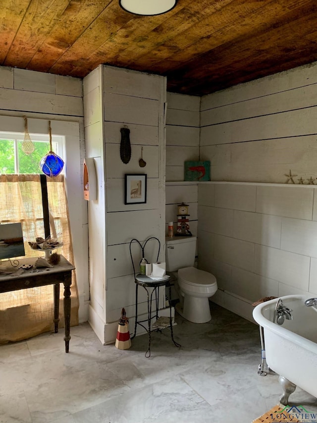 bathroom with a tub to relax in, toilet, wood ceiling, and wooden walls