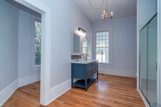 bathroom with a chandelier, ornamental molding, hardwood / wood-style flooring, and vanity