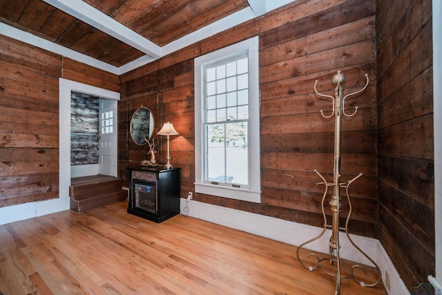 interior space with beamed ceiling, wood walls, hardwood / wood-style flooring, and wooden ceiling