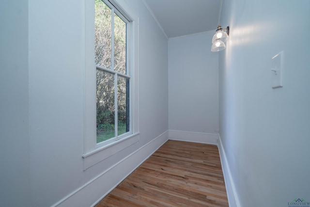 unfurnished room with light wood-type flooring and ornamental molding