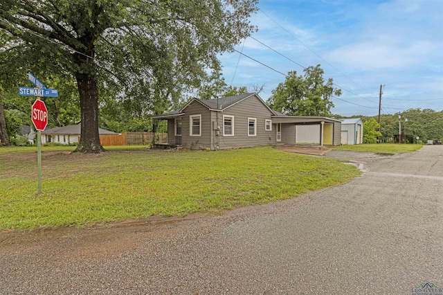 524 N College St, Lindale, TX 75771 - view of front of property featuring driveway, a carport, and an outbuilding