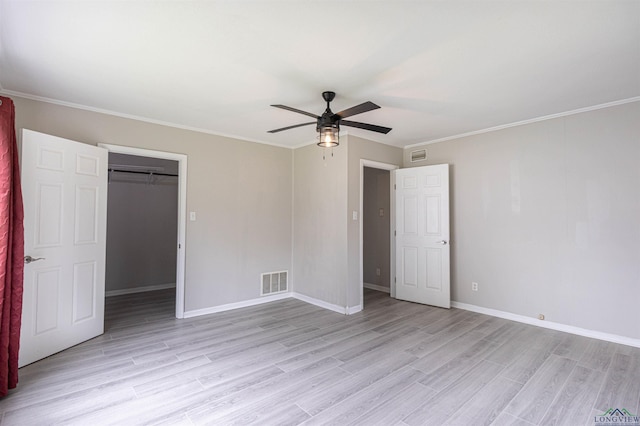 524 N College St, Lindale, TX 75771 - unfurnished bedroom featuring light wood-style flooring, a spacious closet, a ceiling fan, a closet, and crown molding