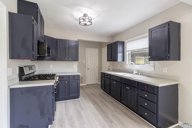 524 N College St, Lindale, TX 75771 - kitchen featuring stainless steel range with gas stovetop, light wood-style floors, and light countertops