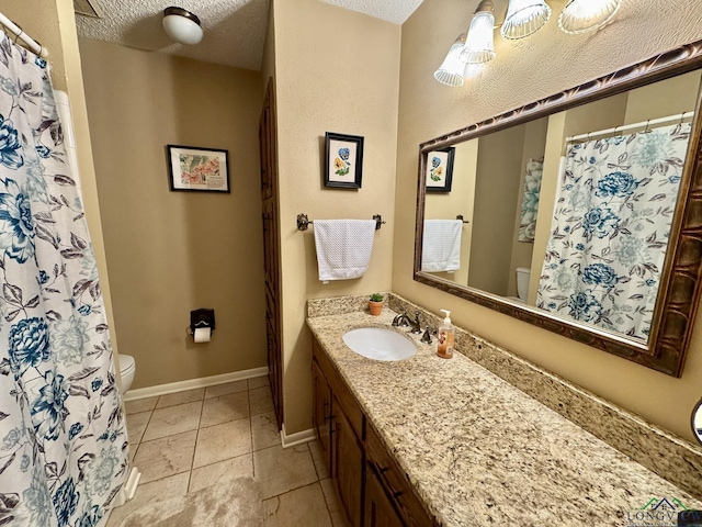 3201 Restview St, Longview, TX 75605 - full bath featuring toilet, vanity, a textured ceiling, baseboards, and tile patterned flooring
