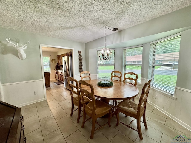 3201 Restview St, Longview, TX 75605 - dining room featuring wainscoting, a textured ceiling, a chandelier, and light tile patterned floors