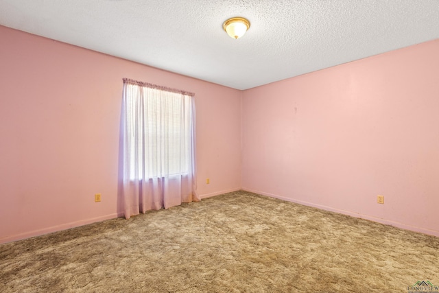 unfurnished room with a textured ceiling, baseboards, and carpet floors