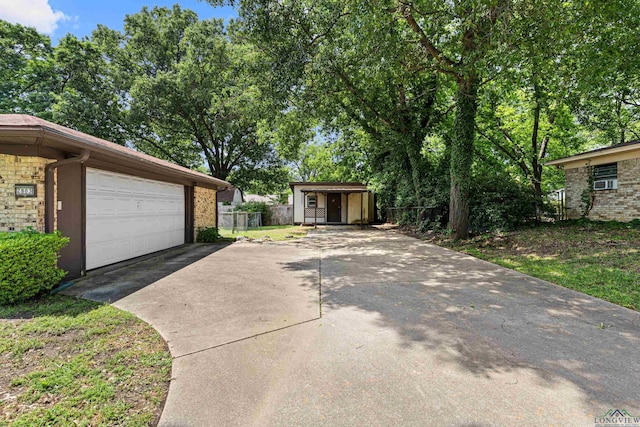 view of side of home with a garage, brick siding, and fence
