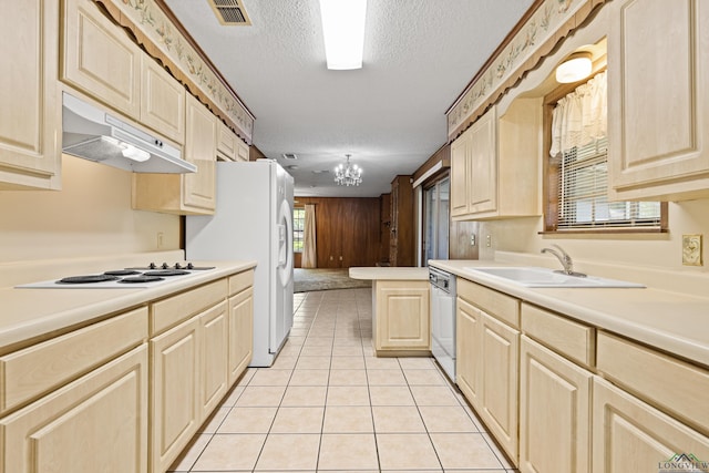 kitchen featuring a sink, visible vents, light countertops, under cabinet range hood, and a notable chandelier