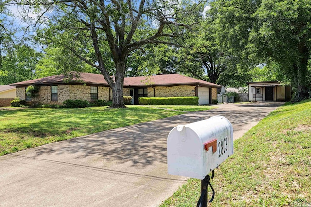 ranch-style house featuring a garage, brick siding, aphalt driveway, and a front lawn