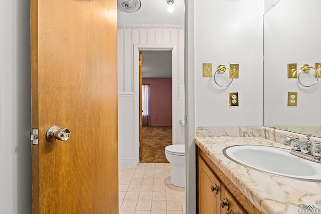 bathroom with vanity, toilet, and tile patterned flooring