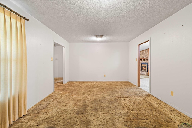 empty room with a textured ceiling and carpet flooring