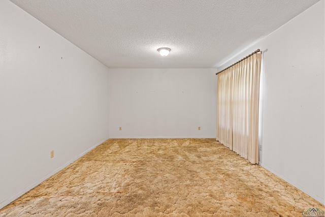 unfurnished room with a textured ceiling and carpet floors