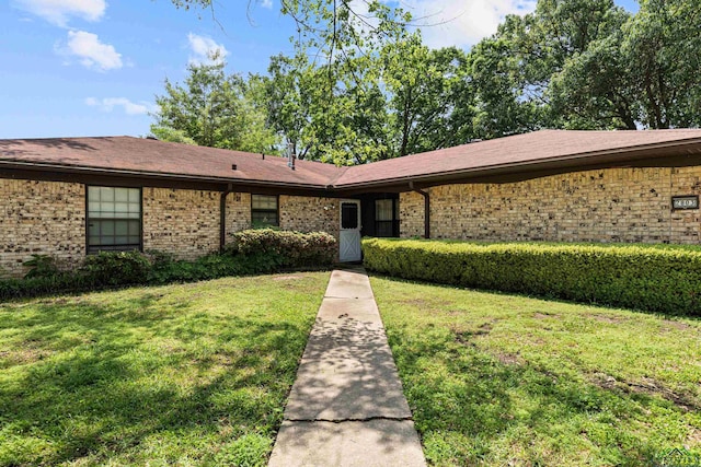 view of front facade featuring a front yard and brick siding
