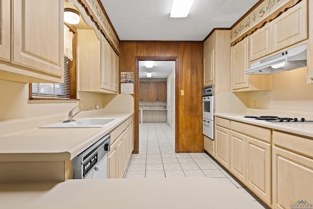 kitchen featuring wooden walls, light brown cabinets, white appliances, and under cabinet range hood