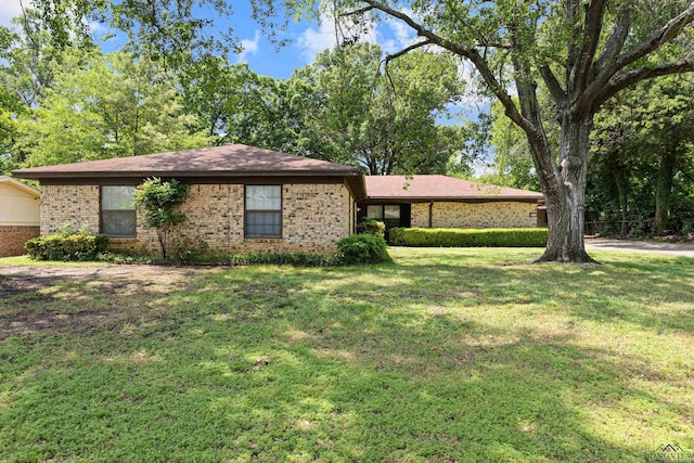 single story home with a front lawn and brick siding