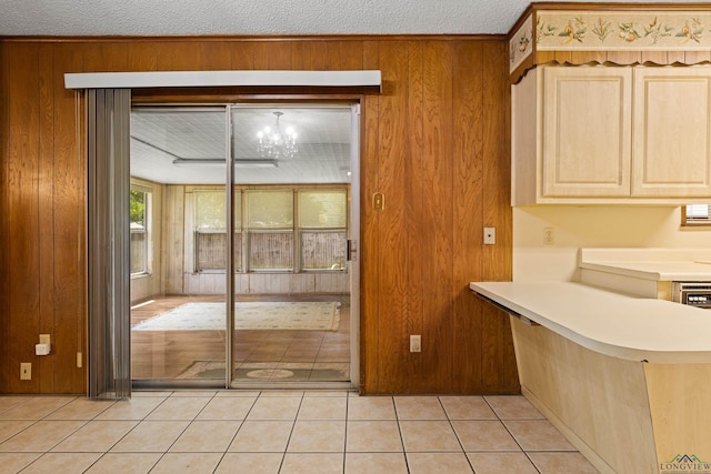 interior space featuring light tile patterned floors, light brown cabinets, wood walls, and light countertops