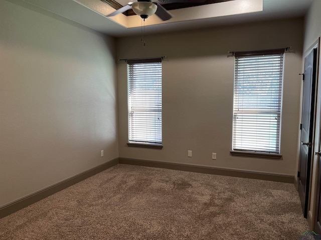 carpeted spare room featuring ceiling fan