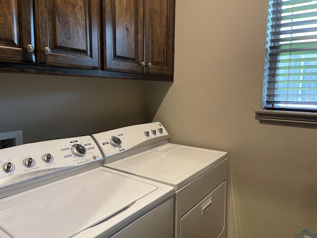 laundry area with washer and clothes dryer and cabinets