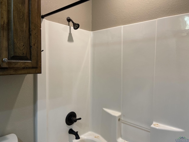 bathroom with toilet and shower / bathtub combination