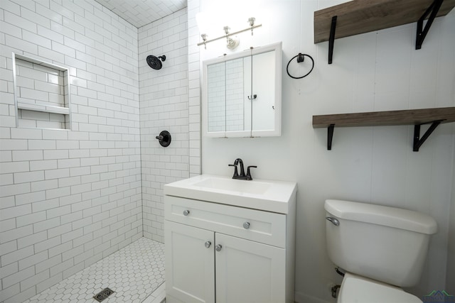 bathroom featuring a shower stall, toilet, and vanity