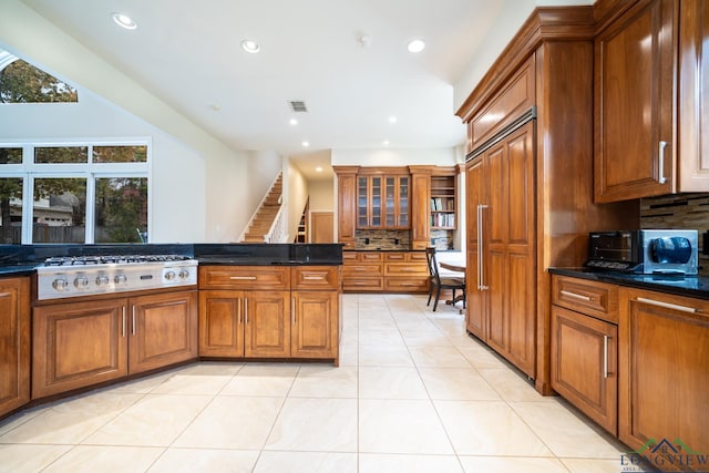 kitchen with decorative backsplash, light tile patterned floors, plenty of natural light, and stainless steel gas stovetop