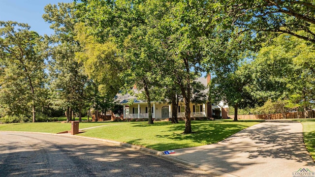 view of property hidden behind natural elements with a front lawn