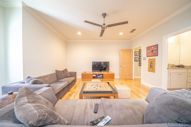 living room with light hardwood / wood-style floors, ceiling fan, and ornamental molding