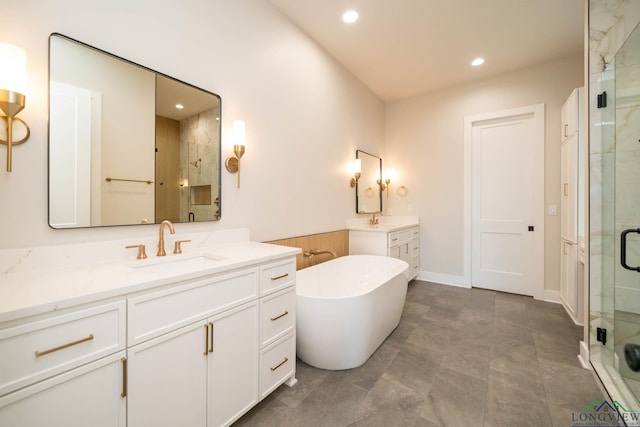 full bathroom with two vanities, a sink, recessed lighting, and a stall shower