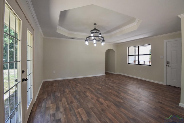 empty room with french doors, a raised ceiling, crown molding, dark hardwood / wood-style flooring, and a chandelier